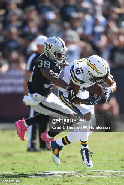 Tyrell Williams of the Los Angeles Chargers catches a pass and gets tackled by T.J. Carrie of the Oakland Raiders during an NFL football game at...