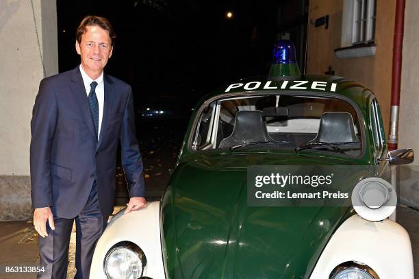 Presenter Rudi Cerne poses during the 'Aktenzeichen XY... Ungeloest' 50th anniversary celebration at Park Cafe next to a historic police car on...