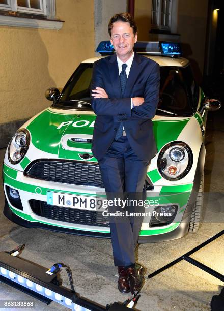 Presenter Rudi Cerne poses during the 'Aktenzeichen XY... Ungeloest' 50th anniversary celebration at Park Cafe infront of a police car on October 19,...