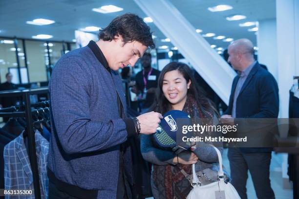 Seattle Seahawks Tight End Luke Willson signs an autograph for a fan during the Saks OFF 5TH Seattle VIP Grand Opening Party on October 18, 2017 in...