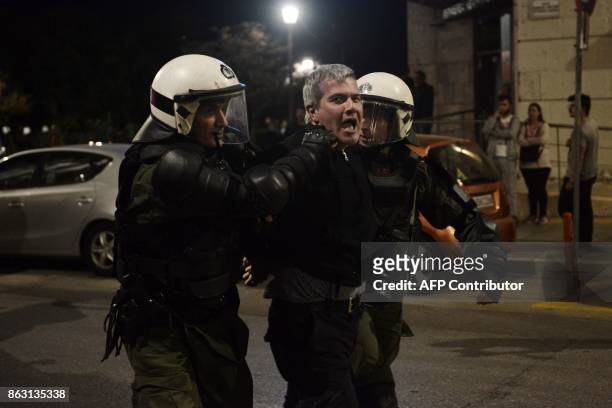 Anti-riot policemen arrest a member of orthodox religious organizations as they demonstrate outside a theater against the play of Portuguese writer...