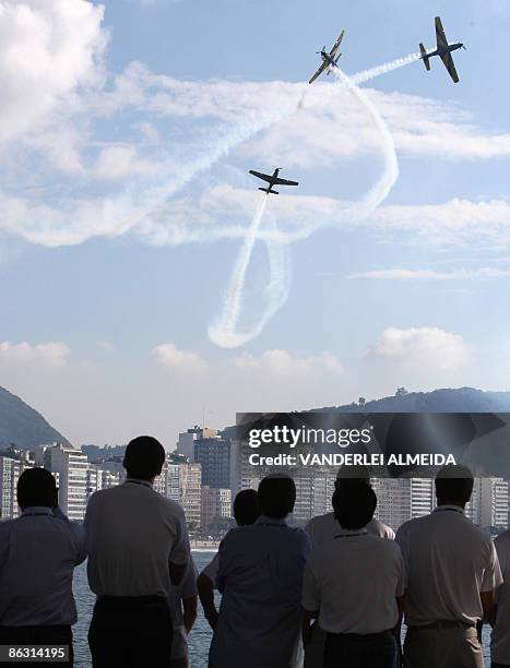 Members of the IOC Evaluation Commission watch the evolutions of the "Smoke Wing" acrobatic air unit from the military fort in Copacabana Beach in...