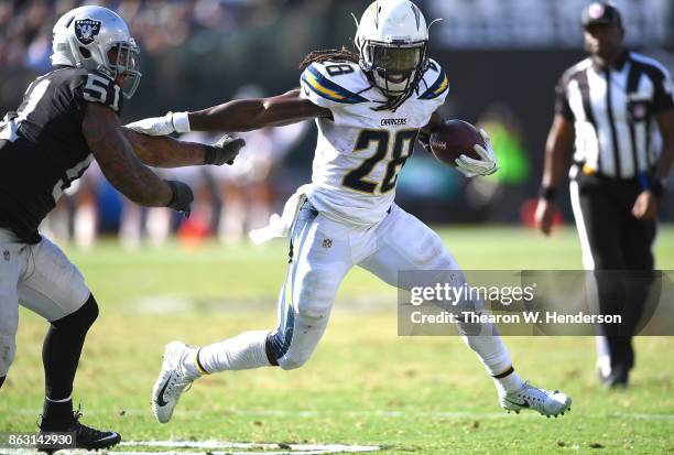 Melvin Gordon of the Los Angeles Chargers fights off the tackle of Bruce Irvin of the Oakland Raiders during an NFL football game at Oakland-Alameda...