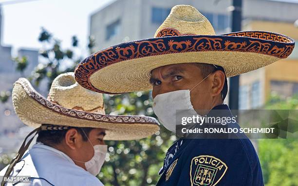 Mexican mounted police stand guard wearing surgery masks at Alameda Square in Mexico City on May 1, 2009. Few people can be seen in the almost empty...