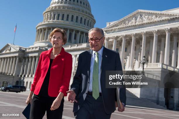 Senate Minority Leader Charles Schumer, D-N.Y., and Sen. Elizabeth Warren, D-Mass., make their way to a news conference on the east lawn of the...