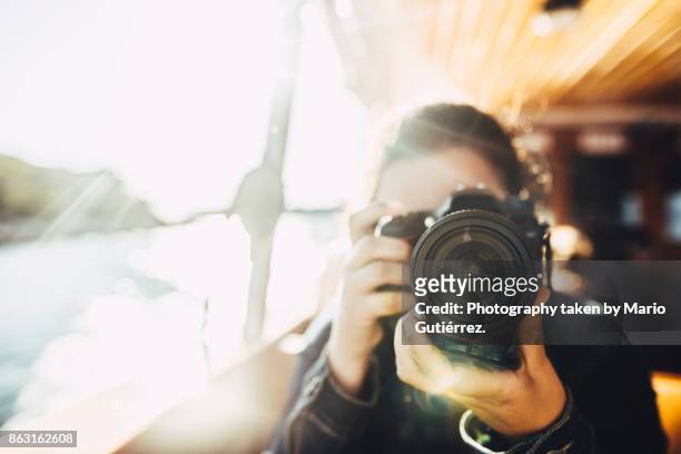 young woman using a dslr camera - fotografie benodigdheden stockfoto's en -beelden