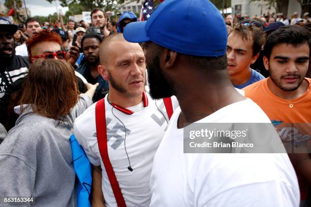 Man wearing a shirt with swastikas is forced away from the scene by the crowd moments before being punched by an unidentified member of the crowd...