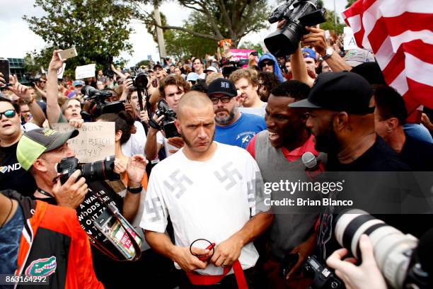 Man wearing a shirt with swastikas is forced away from the scene by the crowd moments after being punched by an unidentified member of the crowd near...