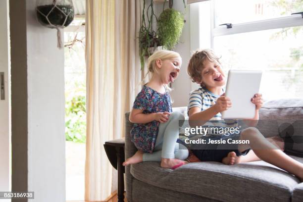 siblings - blonde girl sticking out her tongue stock pictures, royalty-free photos & images