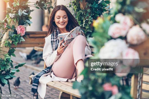 young woman reading a book outdoors - feet up stock pictures, royalty-free photos & images