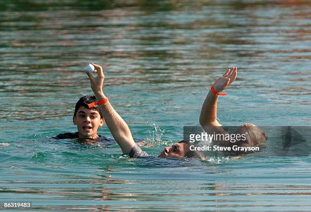 Fans retrieve Fred Funk's ball thrown in a water hazard by Annika Sorenstam on the seventh green during the first round of the Merrill Lynch Skins...