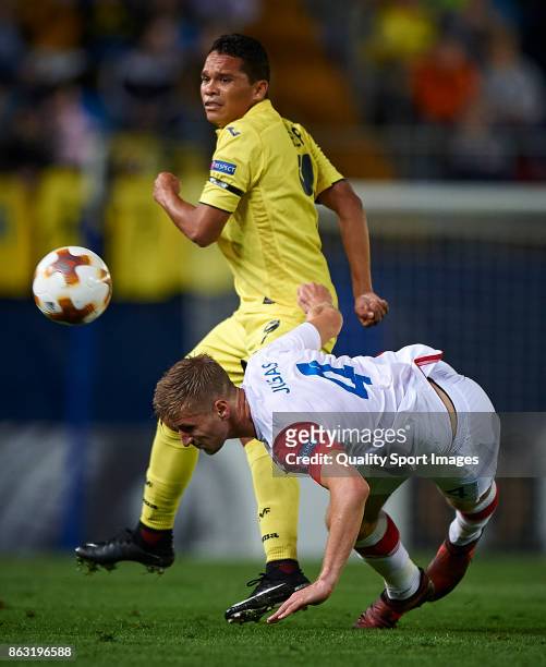Carlos Bacca of Villarreal competes for the ball with Jakub Jugas of Slavia Praha during the UEFA Europa League group A match between Villarreal CF...