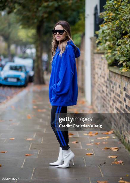 Maria Hatzistefanis wearing blue Vetements jumper, hoddy with European Union print, striped Etre Cecile pants, white Balenciaga shoes, Celine...
