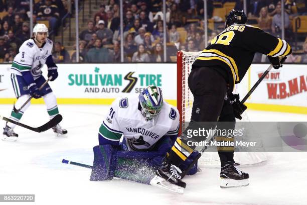 Kenny Agostino of the Boston Bruins takes a shot against Anders Nilsson of the Vancouver Canucks during the first period at TD Garden on October 19,...
