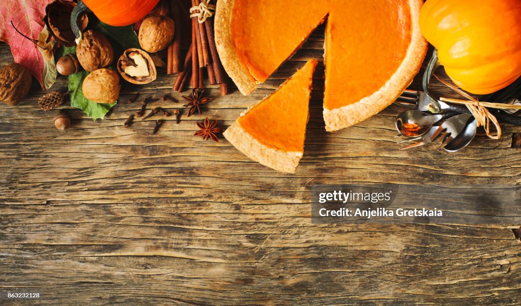 Autumn background with pumpkin pie, pumpkins, nuts and spices