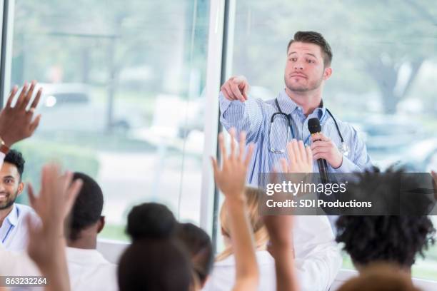 healthcare professionals ask questions during medical seminar - doctor speech stock pictures, royalty-free photos & images