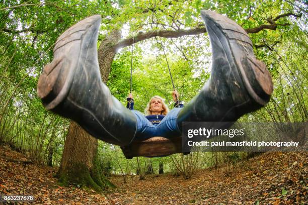 mature blond lady on rope swing - fisheye stock pictures, royalty-free photos & images