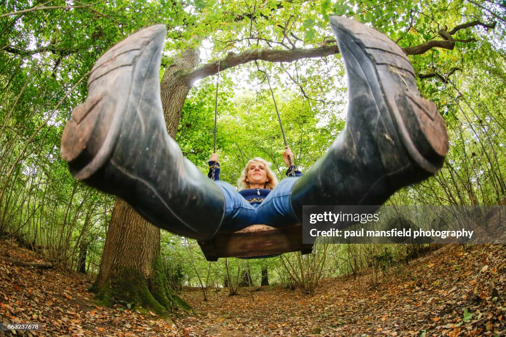 Mature blond lady on rope swing