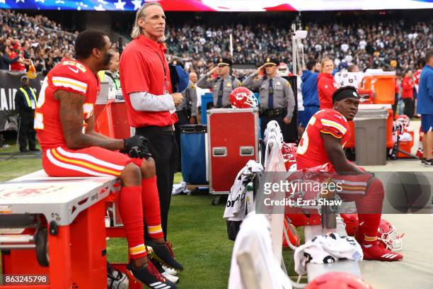 Marcus Peters and Ukeme Eligwe of the Kansas City Chiefs sit on the bench during the national anthem prior to their NFL game against the Oakland...