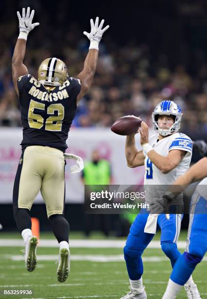 Matthew Stafford of the Detroit Lions looks to throw a pass under pressure from Craig Robertson of the New Orleans Saints at Mercedes-Benz Superdome...