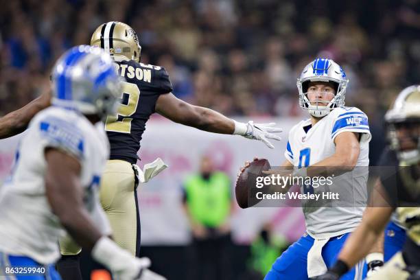 Matthew Stafford of the Detroit Lions has the ball knocked out of his hands by Craig Robertson of the New Orleans Saints at Mercedes-Benz Superdome...