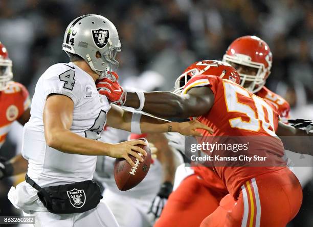 Kansas City Chiefs outside linebacker Justin Houston grabs the facemask of Oakland Raiders quarterback Derek Carr for a penalty in the second quarter...