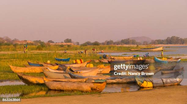 traditional african boats on shore in morning on lake malawi near salima malawi - see lake malawi stock-fotos und bilder