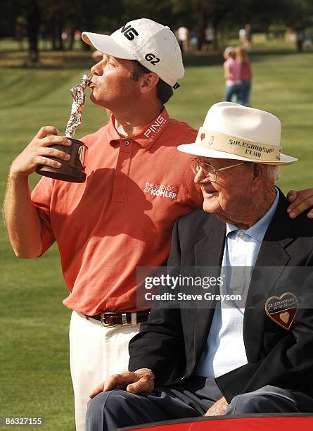 Ted Purdy kisses the winner's trophy as Byron Nelson looks on the 18th green during the final round of the 2005 EDS Byron Nelson Championship at TPC...