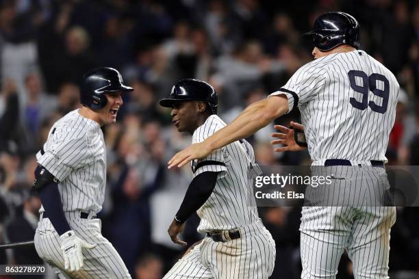 Didi Gregorius and Aaron Judge of the New York Yankees celebrate with teammate Greg Bird after scoring in the eighth inning against the Houston...