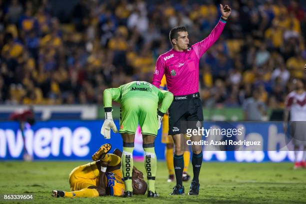Enner Valencia of Tigres lies on the ground as referee Fernando Hernandez asks for medical assistance during the 10th round match between Tigres UANL...