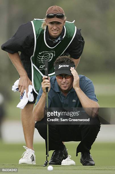 Robert Allenby conferrs with his caddie Dion Kipping, during the first round of the WGC-CA Championship held on the Blue Course at Doral Golf Resort...