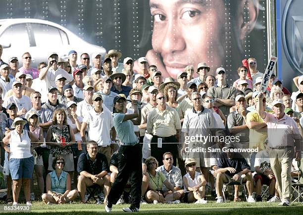 Michelle Wie is watched by Tiger Woods as she tees off on the 7th hole during the second round of the John Deere Championship held at the TPC at...