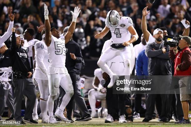 Khalil Mack and Derek Carr of the Oakland Raiders celebrate after the Michael Crabtree touchdown is confirmed by officials to tie their game 30-30...