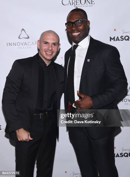 Singer Pitbull and Retired NFL Player Tony Richardson attend Daniel E Straus & CareOne Starry Night Masquerade For Puerto Ricoat Skylight Clarkson...