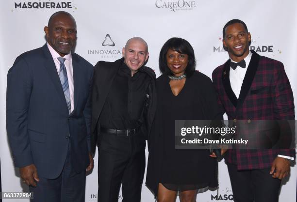 Player Harry Carson, Singer Pitbull, NFL Player Victor Cruz and guest attend Daniel E Straus & CareOne Starry Night Masquerade For Puerto Ricoat...