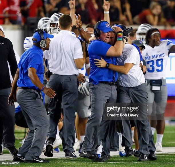 Head coach Mike Norvell of the Memphis Tigers, right, is hugged by his assistants after a comeback win overe the Houston Cougars 42-38 on October 19,...