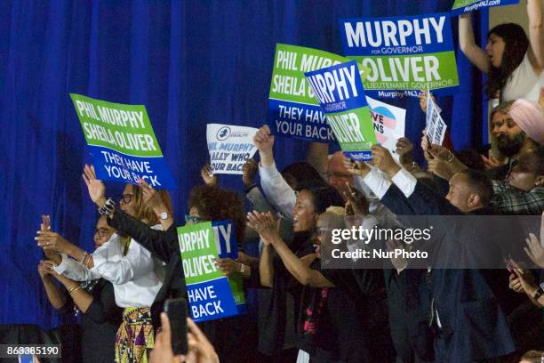 People hold signs in support of Democratic candidate Phil Murphy, who is running against Republican Lt. Gov. Kim Guadagno for the governor of New...