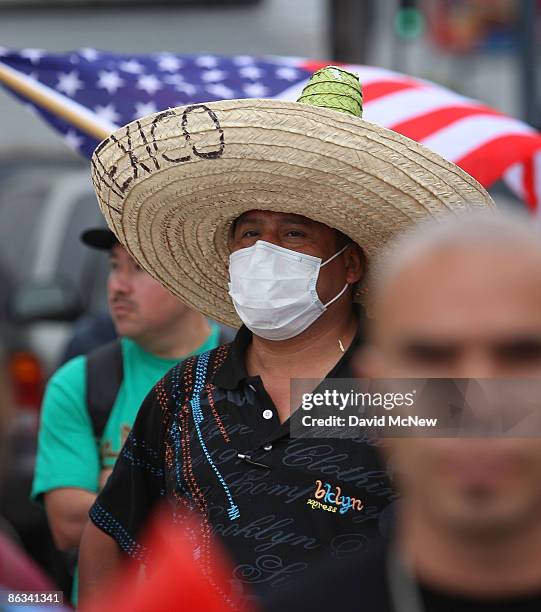 Trujillo Guiermo wears a mask for protection against exposure to the swine flu virus, H1-N1, as demonstrators rally before marching for immigrant...