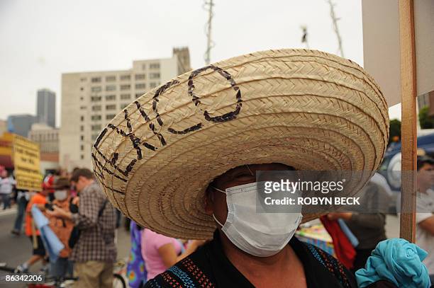 Man wearing a face mask and a sombrero reading "Viva Mexico" participates in an immigrants' rights May Day rally in downtown Los Angeles on May 1,...