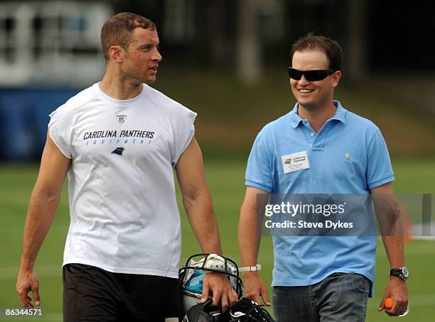 Punter Jason Baker of the Carolina Panthers walks off the field with golfer Zach Johnson after the minicamp practice at the team's practice facility...