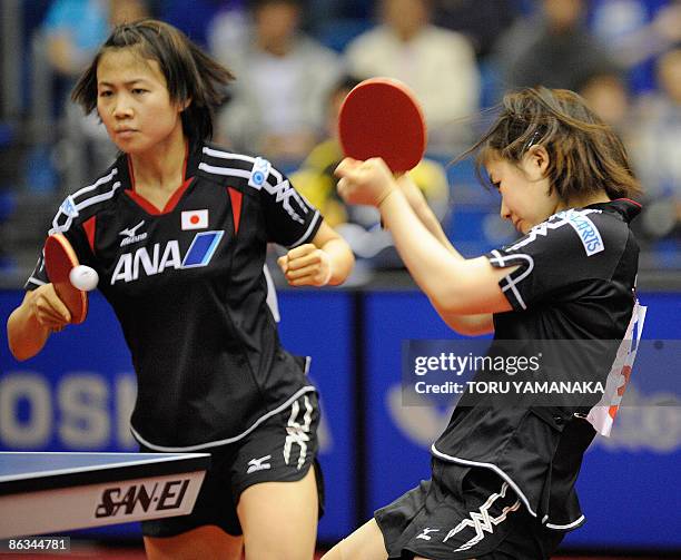 Japanese Ai Fukuhara smashes the ball as her partner Sayaka Hirano looks on during their women's doubles third round match against German Wu Jiaduo...