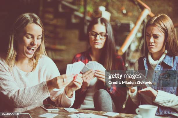 tres chicas en casa jugando a las cartas. - póquer fotografías e imágenes de stock