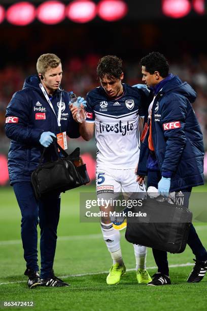 Melbourne's Mark Milligan is sandwiched between Adelaides Vince Lia and Melbourne's Leigh Broxham defending a goal and leaves the field during the...