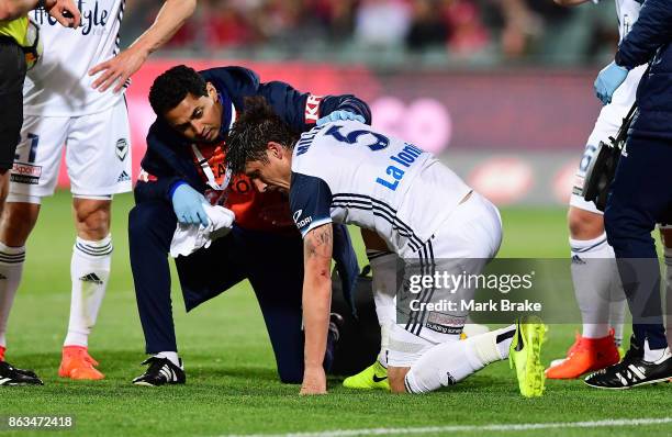 Melbourne's Mark Milligan is sandwiched between Adelaides Vince Lia and Melbourne's Leigh Broxham defending a goal and leaves the field during the...