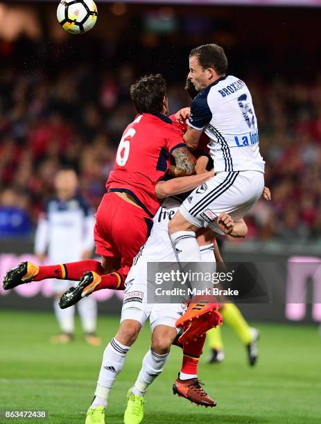 Melbourne's Mark Milligan is sandwiched between Adelaides Vince Lia and Melbourne's Leigh Broxham defending a goal and leaves the field during the...