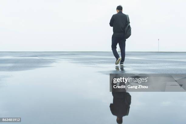 young male athlete taking a walk after a morning rain - puddles stock pictures, royalty-free photos & images