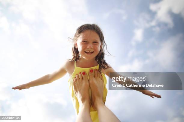 a 7 years old girl flying - child and unusual angle stockfoto's en -beelden