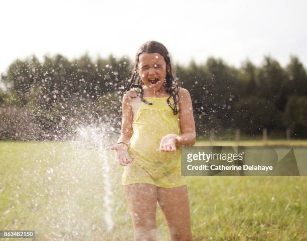 a 8 years old girl playing with water in the countryside - 8 9 years stock-fotos und bilder