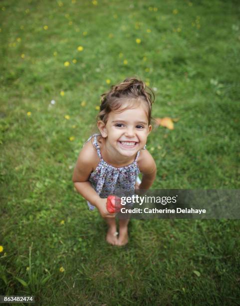 a 3 years old girl eating icecream in the garden - 2 3 years foto e immagini stock