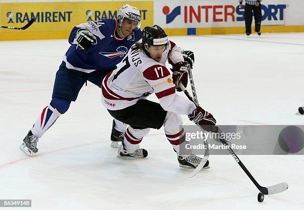 Kevin Hecquefeuille of France fights for the puck with Aleksandrs Nizivijs of Latvia during the IIHF World Ice Hockey Championship qualification...